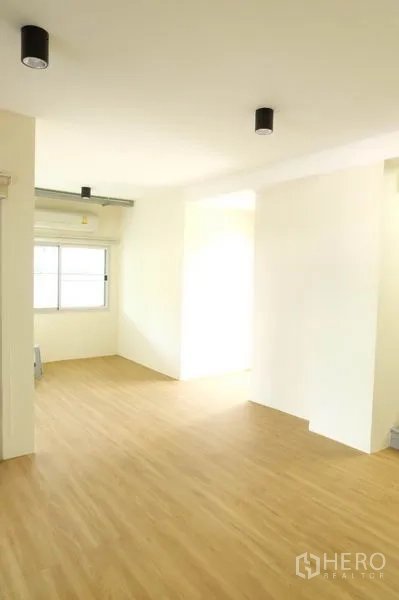 Home Office for rent in Wang Thonglang, Bangkok - Sunlit multifunction room with wood flooring and side window, suitable as workspace.