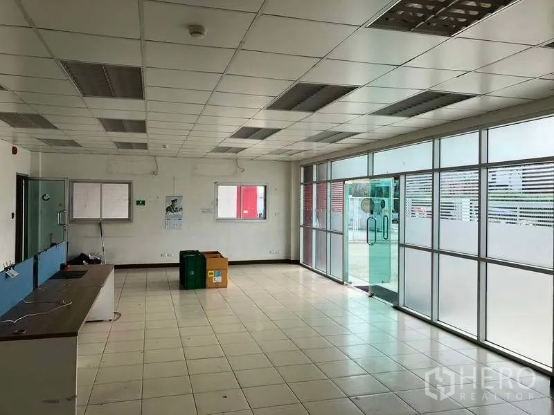 工厂 出租在Bang Sao Thong, Samut Prakan - 开放式办公室，玻璃滑门入口和长工作台。