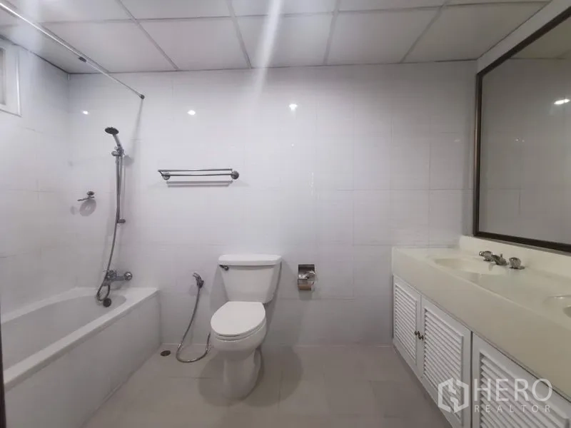 房间 出租在Khlong Toei, Bangkok - 明亮浴室，浴缸带淋浴、白色洗手台与坐便器。