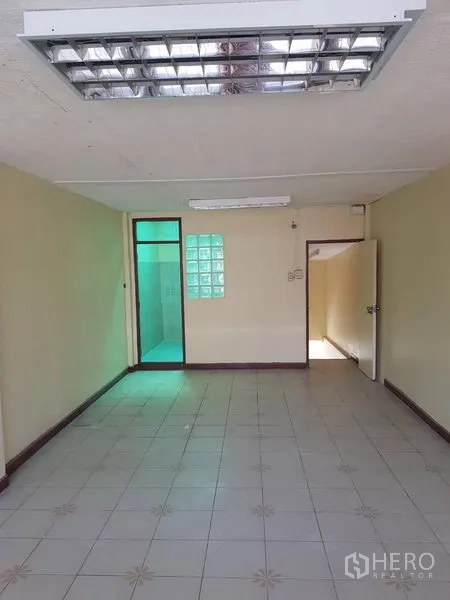 พื้นที่ขายปลีก ให้เช่าในKhlong Toei, Bangkok - พื้นที่โล่งปูพื้นกระเบื้อง ไฟนีออน พร้อมประตูสู่ห้องน้ำด้านหลังผนังกั้นบล็อกแก้ว