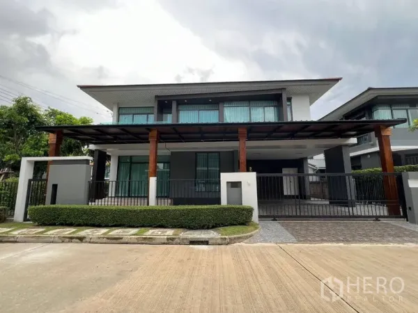 Detached House for rent in Bang Kapi, Bangkok - Modern two-storey detached house facade with gated entrance and a wide covered carport.