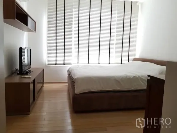 公寓 出租在Khlong Toei, Bangkok - 卧室配大窗百叶、木地板、双人床与电视柜，采光充足