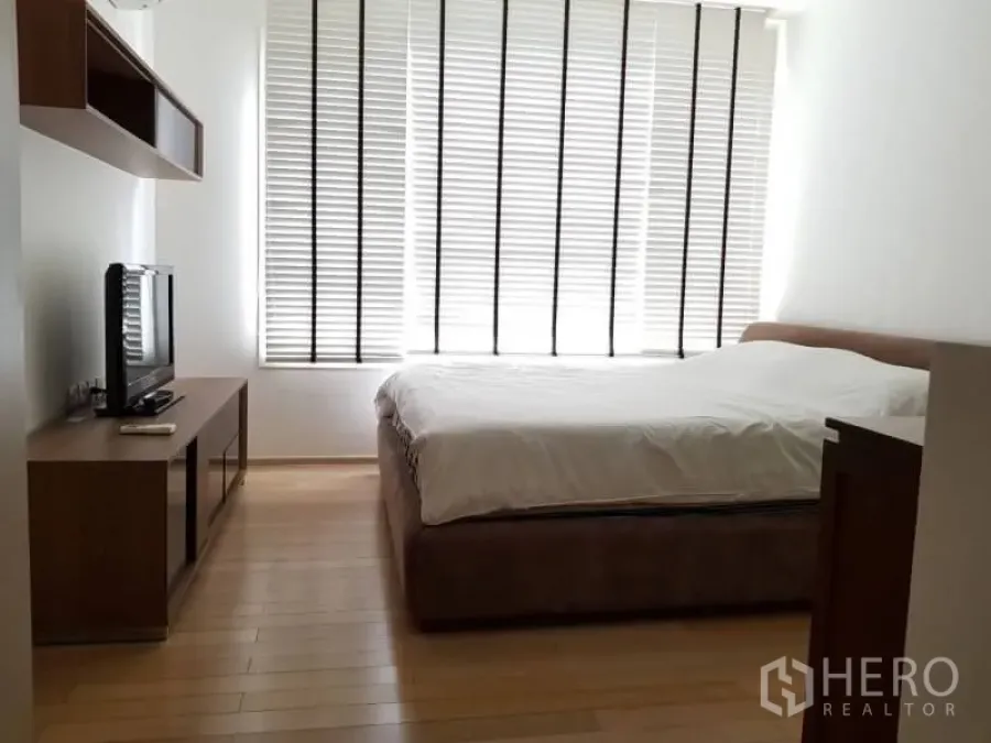 公寓 出租在Khlong Toei, Bangkok - 卧室配大窗百叶、木地板、双人床与电视柜，采光充足