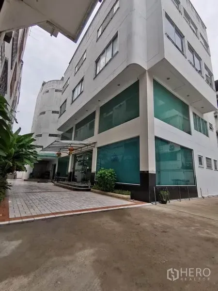 สำนักงาน ให้เช่าในKhlong San, Bangkok - มุมมองอาคารสำนักงานหลายชั้น กระจกสีเขียว พร้อมทางเข้าและหลังคากันฝนด้านหน้า