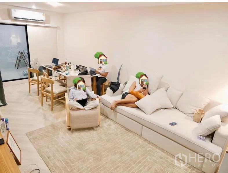 Townhouse for rent in Bang Kapi, Bangkok - Bright open-plan living and dining area with a long sofa, dining table, and sliding glass door.