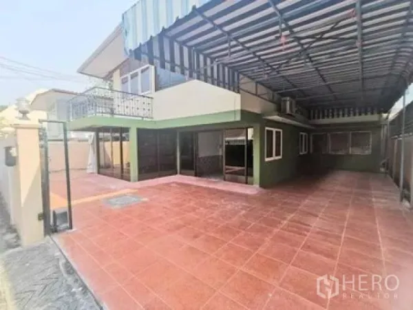 Home Office for rent in Wang Thonglang, Bangkok - Spacious front terrace with red floor tiles, striped metal canopy, balcony and sliding glass doors.