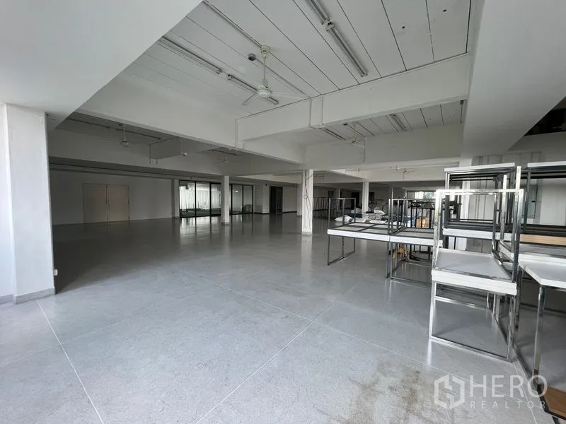 Office Space for rent in Mueang Samut Prakan, Samut Prakan - Open hall with stainless shelving units and grey tiled floors.