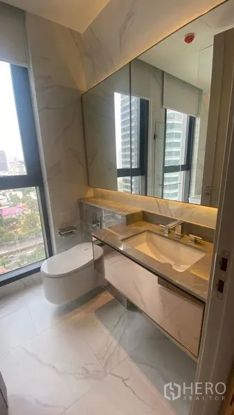 Condominium for rent - Modern bathroom with marble tiles, floating vanity, large mirror and window.