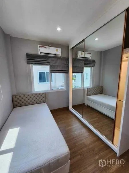 独立式住宅 出租在Bang Khen, Bangkok - 采光良好的小卧室，单人床、镜面衣柜、木地板与空调。