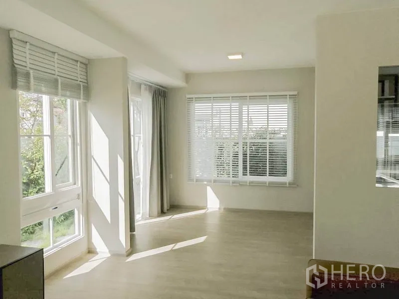 联排别墅 出租在Prawet, Bangkok - 阳光餐客一体空间，多扇窗户配百叶与窗帘，通向花园。