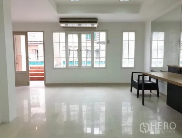 ทาวน์เฮาส์ ให้เช่าหรือขายในChatuchak, Bangkok - พื้นที่นั่งเล่นเปิดโล่ง พื้นกระเบื้องเงา หน้าต่างบานกว้าง ประตูออกระเบียง และเครื่องปรับอากาศ.