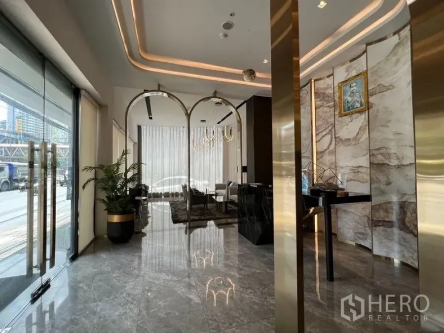 店屋 出租或出售在Din Daeng, Bangkok - 临街入口，玻璃门、岩纹背景墙与拱形装饰，自然采光充足。