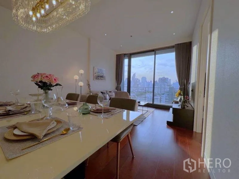 公寓 出租在Watthana, Bangkok - 餐桌布置六人位，吊灯下望向客厅与阳台景致。