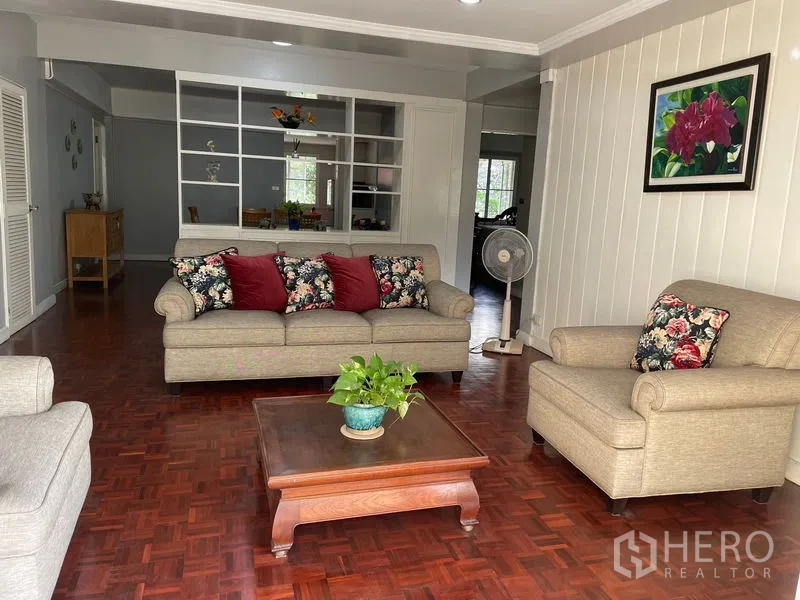 公寓 出租在Watthana, Bangkok - 开放式起居区，沙发组合、茶几与白色展示柜。