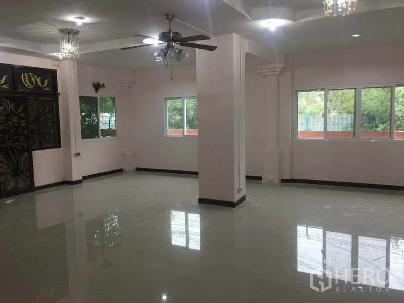 บ้าน ให้เช่าในChatuchak, Bangkok - พื้นที่นั่งเล่นเปิดโล่งสว่าง มีหน้าต่างหลายบาน พัดลมเพดาน และโคมระย้า