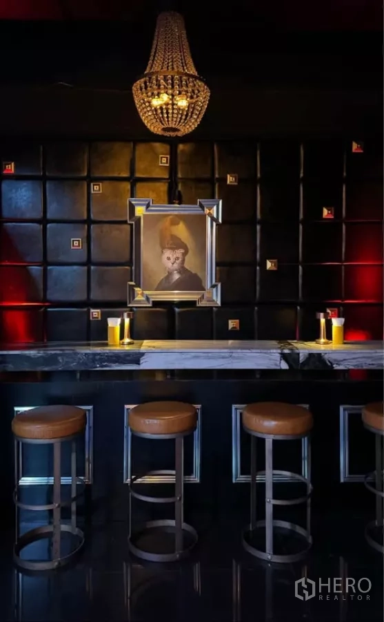 零售空间 出租在Watthana, Bangkok - 高吧台区，皮革高脚凳与软包墙面及装饰画。