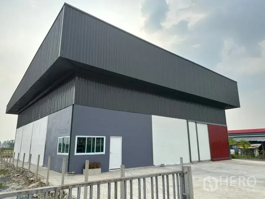 Warehouse for rent in Bang Bua Thong, Nonthaburi - Modern steel‑clad warehouse exterior with high eaves, wide sliding loading doors and a concrete yard in Bang Bua Thong, Nonthaburi.
