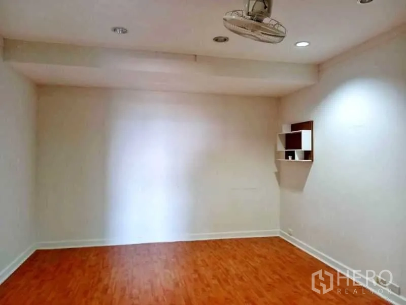 คอนโด ให้เช่าในKhlong Toei, Bangkok - ห้องเอนกประสงค์โล่ง พื้นไม้ ไฟดาวน์ไลท์ และชั้นวางติดผนัง