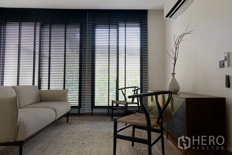 บ้าน ให้เช่าในWatthana, Bangkok - มุมนั่งเล่นอบอุ่น โซฟา เก้าอี้ไม้ และมู่ลี่สูง