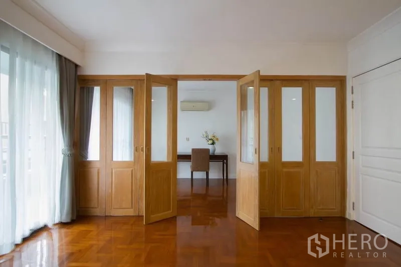 คอนโด ให้เช่าในWatthana, Bangkok - ประตูบานพับกระจกไม้เปิดสู่ห้องทำงานสว่างใกล้ผ้าม่านระเบียง