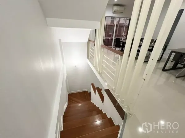 Home Office for rent in Bueng Kum, Bangkok - Staircase with wooden treads and white railing overlooking the office level.