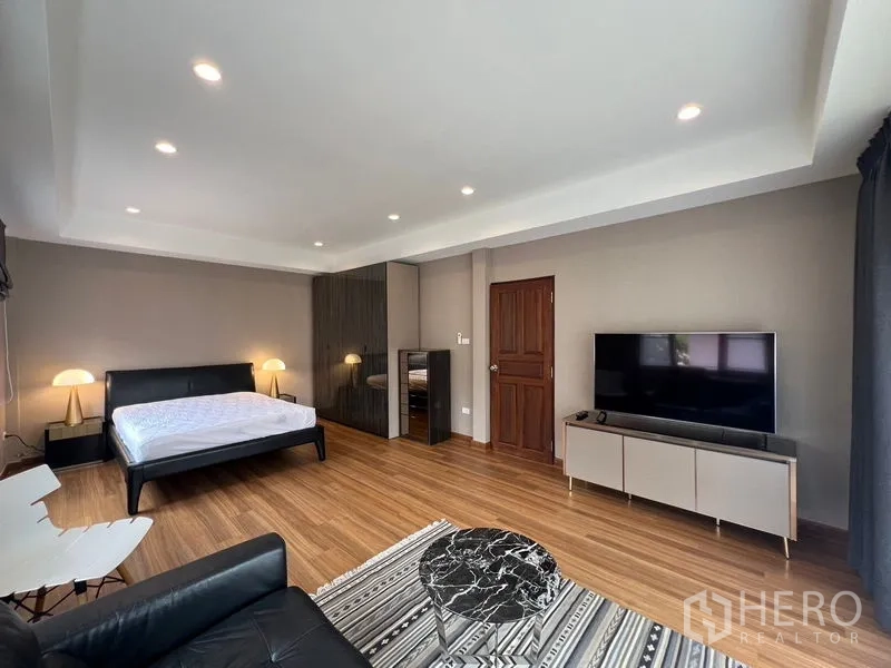 Detached House for sale in Mueang Pathum Thani, Pathum Thani - Large master bedroom with wood flooring, TV and access to the walk-in closet.