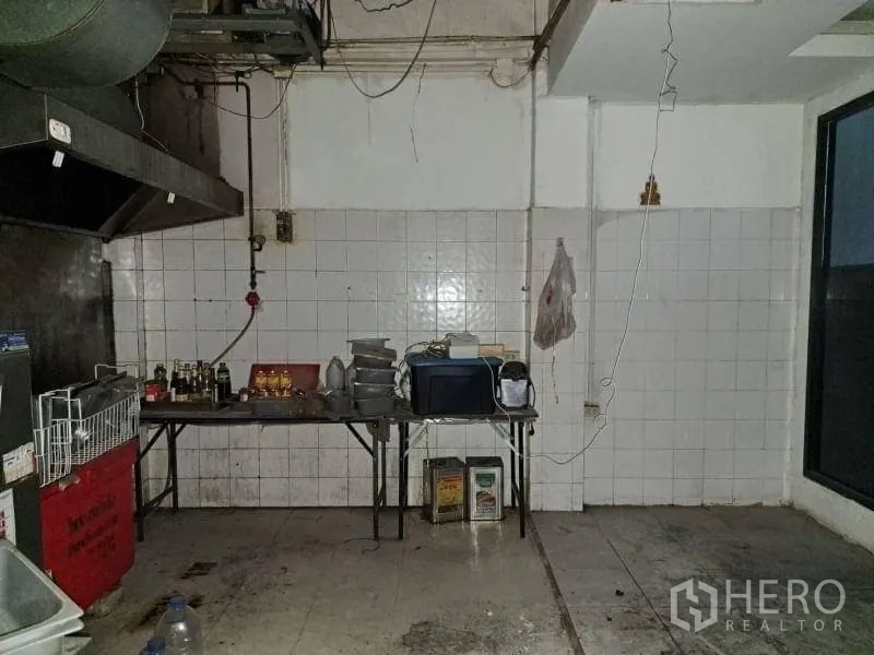Retail Space for rent - Back‑of‑house kitchen with tiled walls and an industrial exhaust hood ready for fit‑out.