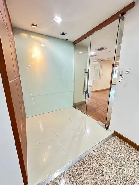 Office Space for rent - Glass-door office entrance with frosted partition and tiled foyer leading to wood-floor workspace.