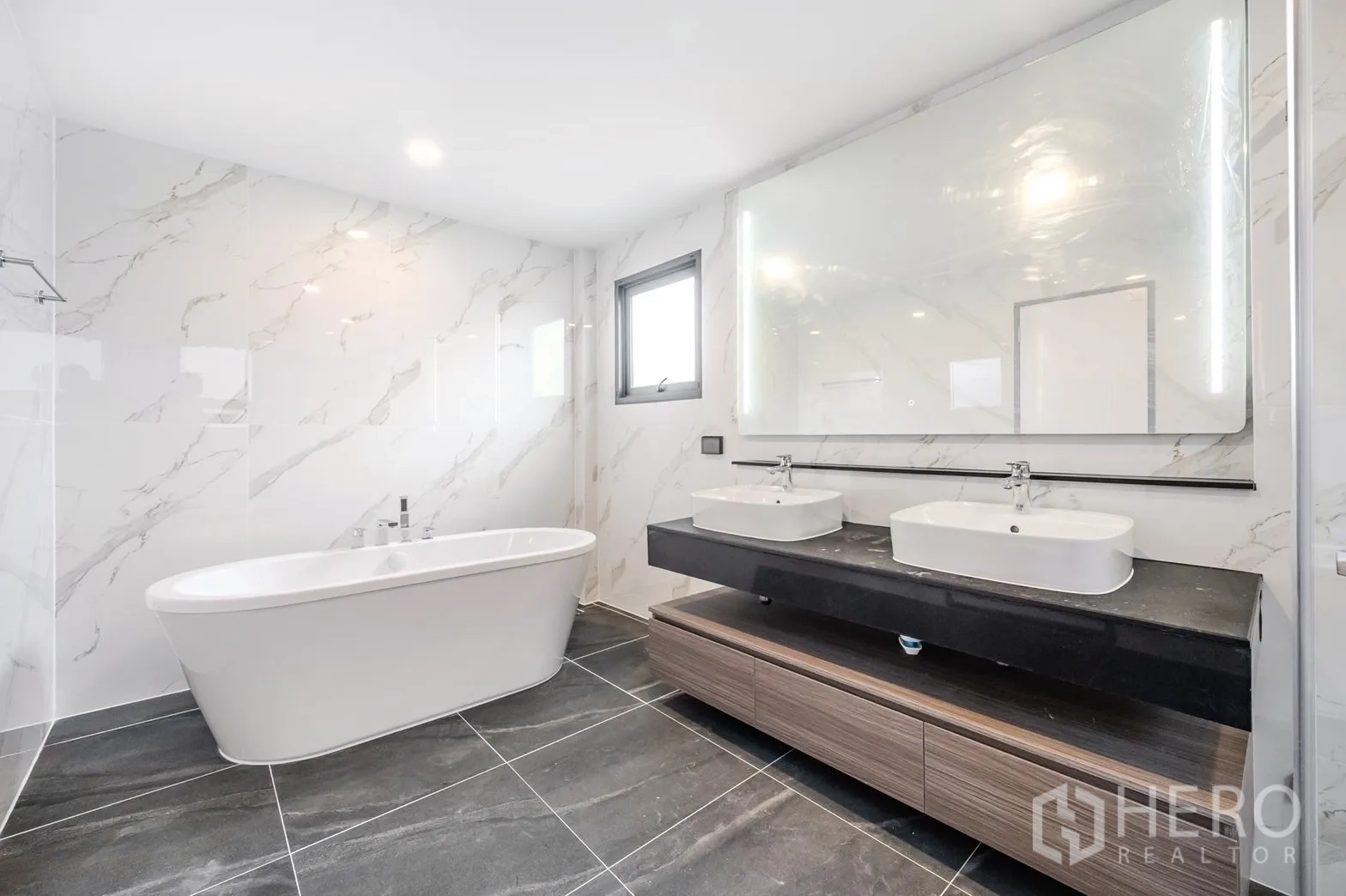 Detached House for rent in Bang Phli, Samut Prakan - Freestanding white bathtub against marble-style wall tiles