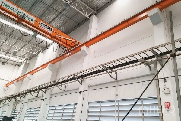 工厂 出售在Rayong - 行车主梁特写，墙面电缆桥架与通风百叶窗。