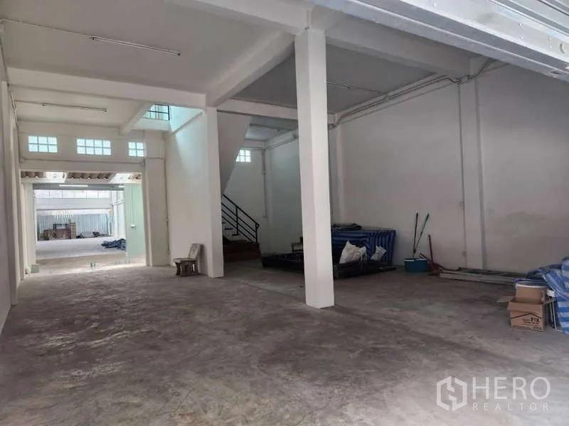 店屋 出租在Khlong Toei, Bangkok - 开阔展厅带支柱，高天花与高侧窗采光。