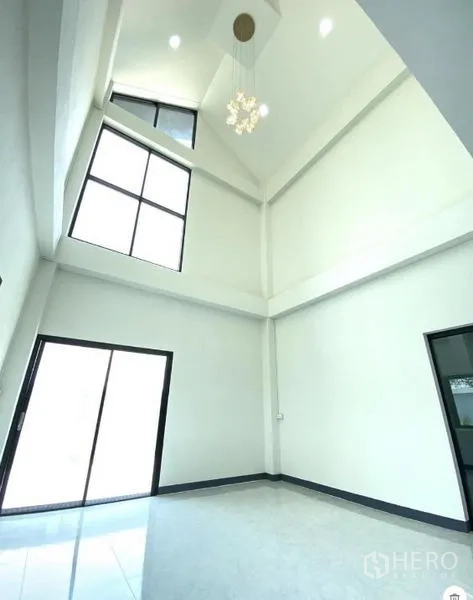 Warehouse for rent in Lat Lum Kaeo, Pathum Thani - Double‑height lobby with tall glazing, sliding door and statement light fixture.