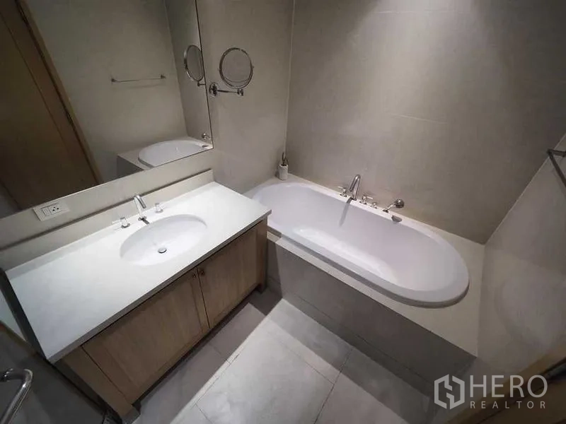 公寓 出租在Khlong Toei, Bangkok - 现代浴室，洁白台面与大镜子，内置浴缸