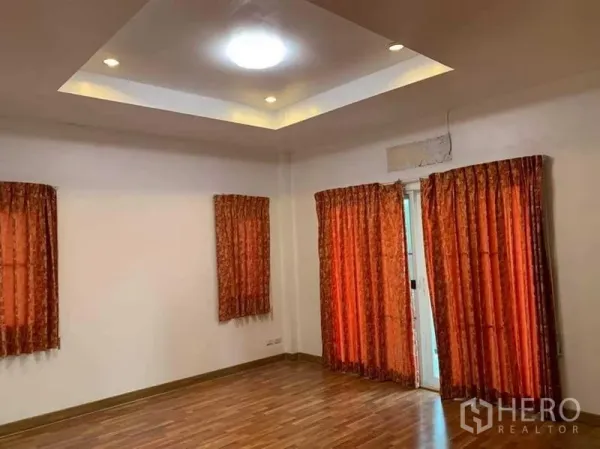 บ้าน ขายในSai Mai, Bangkok - ห้องกว้าง เพดานหลุมพร้อมไฟดาวน์ไลท์ ผ้าม่านสีแดง พื้นไม้