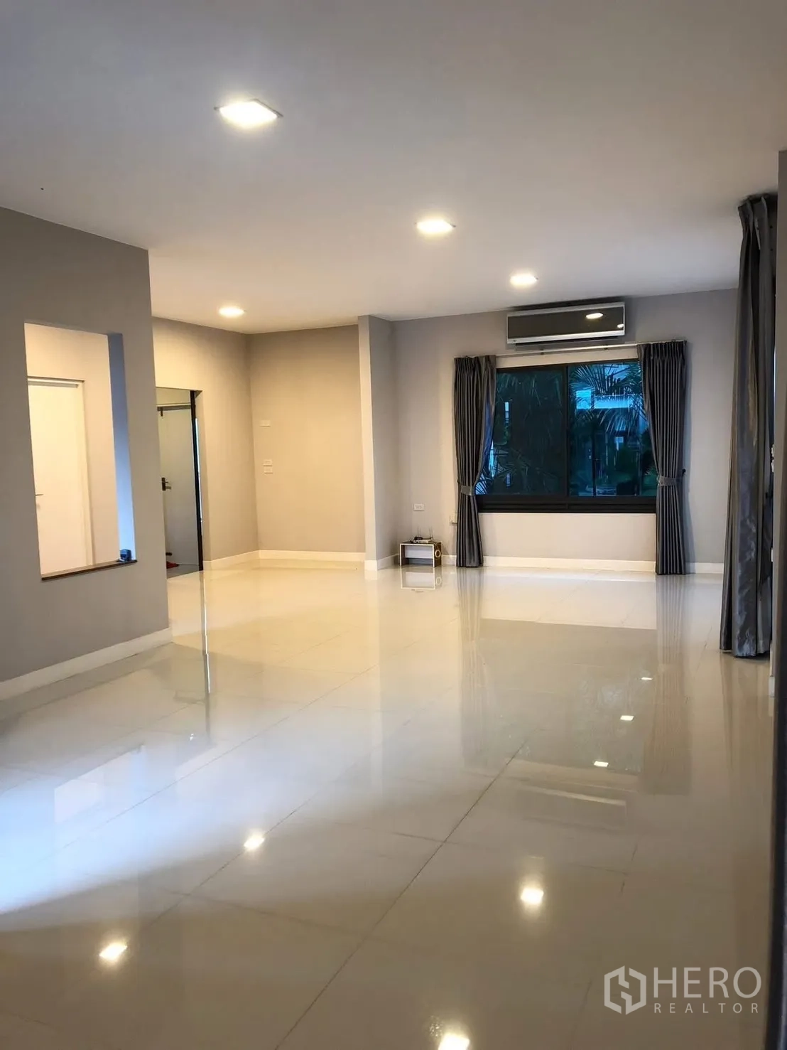 บ้านเดี่ยว for rent in Prawet, Bangkok - พื้นที่นั่งเล่นแบบเปิดโล่ง ปูกระเบื้องสีขาว หน้าต่างบานใหญ่และเครื่องปรับอากาศติดผนัง