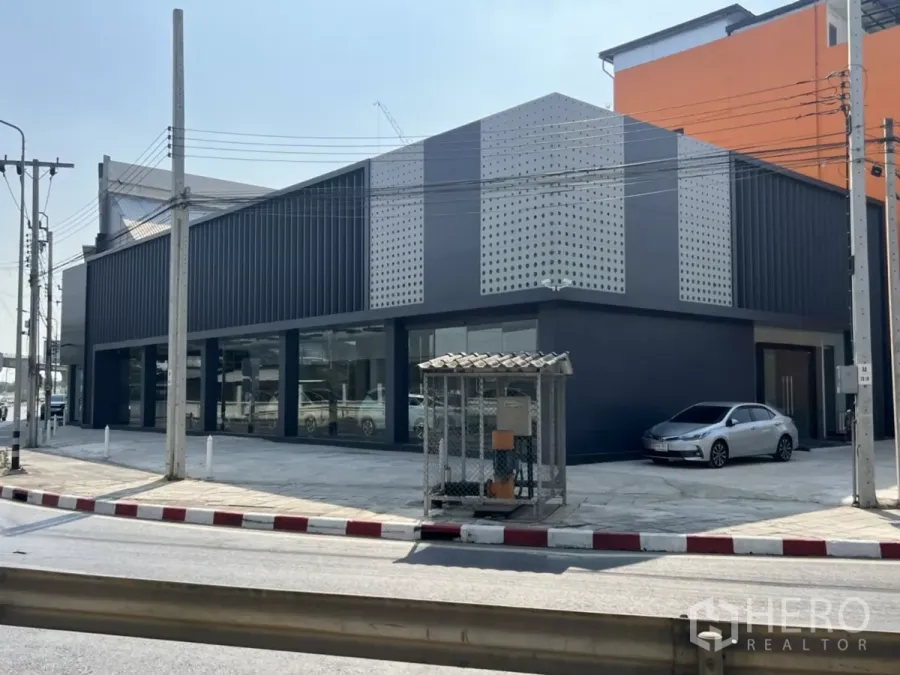 展厅 出租在Khan Na Yao, Bangkok - 位于主干道转角的现代灰色展示厅，落地窗与打孔金属立面，地处Khan Na Yao。
