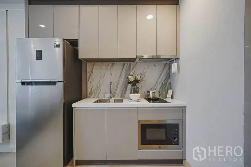 คอนโด ขายในKhlong Toei, Bangkok - ครัวบิลท์อินขนาดกะทัดรัด ผนังลายหินอ่อน ตู้เก็บของ เตา ไมโครเวฟ และตู้เย็นสแตนเลส