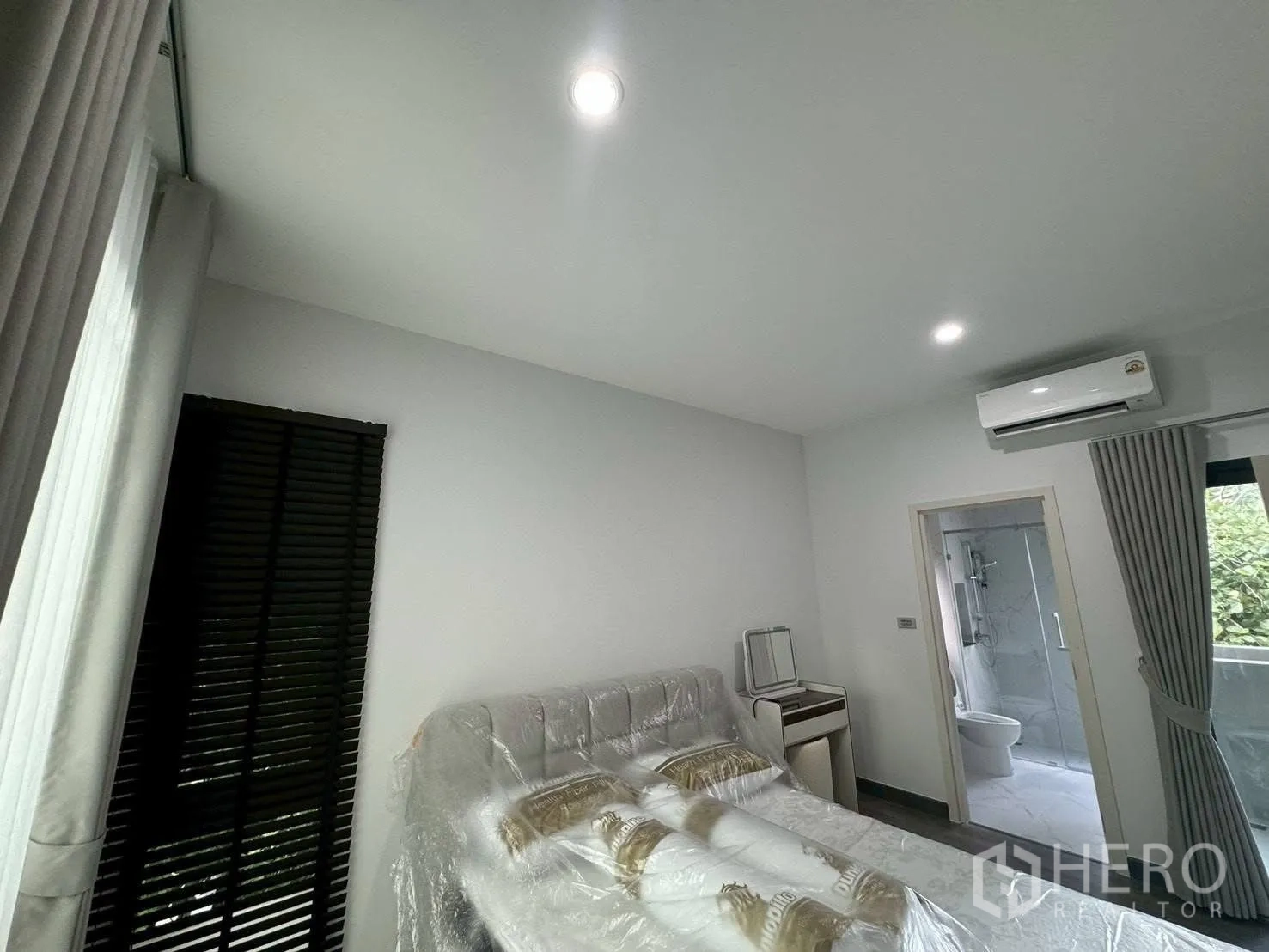 Semi-detached House for rent in Suan Luang, Bangkok - Bright bedroom with bed, air conditioner and adjoining bathroom.