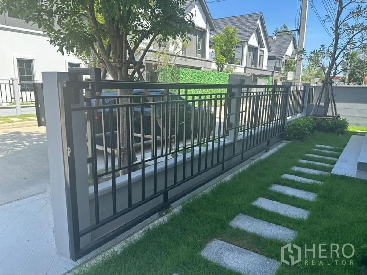 บ้านเดี่ยว for rent in Bang Phli, Samut Prakan - สนามหญ้าหน้าบ้านพร้อมรั้วเหล็กและทางเดินแผ่นพื้น