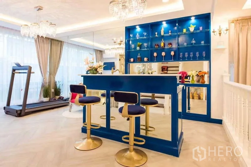 Townhouse for rent in Lat Phrao, Bangkok - Upper-level blue home bar with stools, mirrored shelving and treadmill nearby.