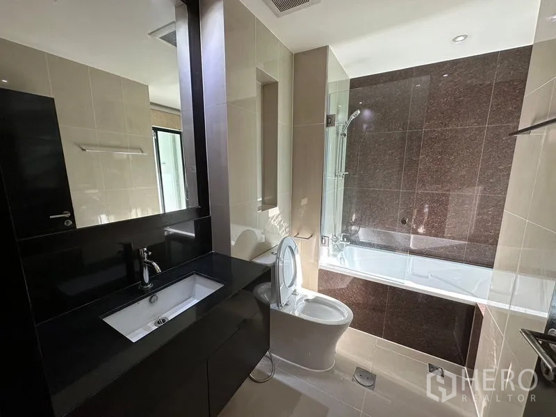 公寓 出租在Sathon, Bangkok - 浴室配浴缸淋浴一体、黑色台面与大镜子