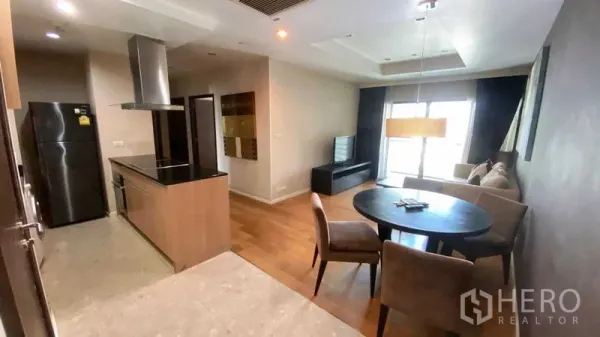 Condominium for rent or sale in Sathon, Bangkok - Open-plan living and dining area with modern kitchen, round table and sofa