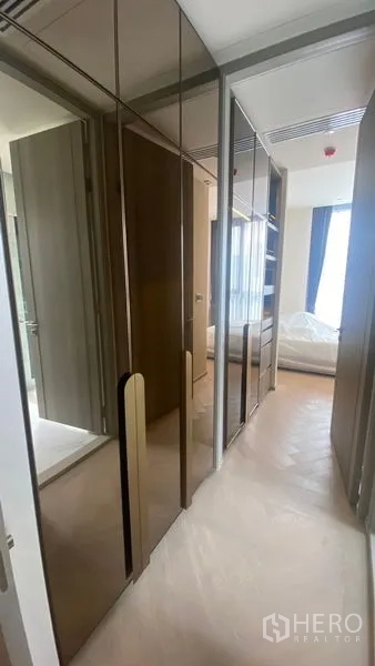 Condominium for rent - Hallway lined with glossy built-in wardrobes leading to the bedroom.