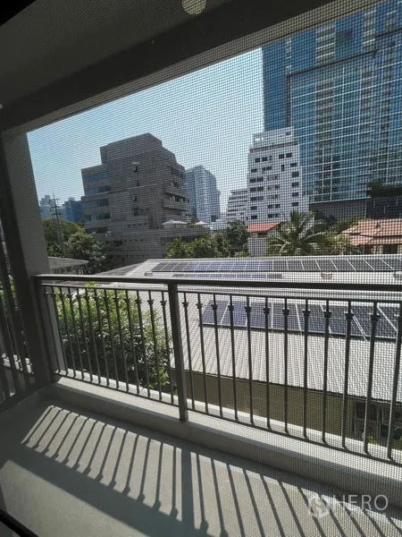 公寓 出租在Pathum Wan, Bangkok - 阳台金属栏杆，可见低层屋顶与曼谷天际线。