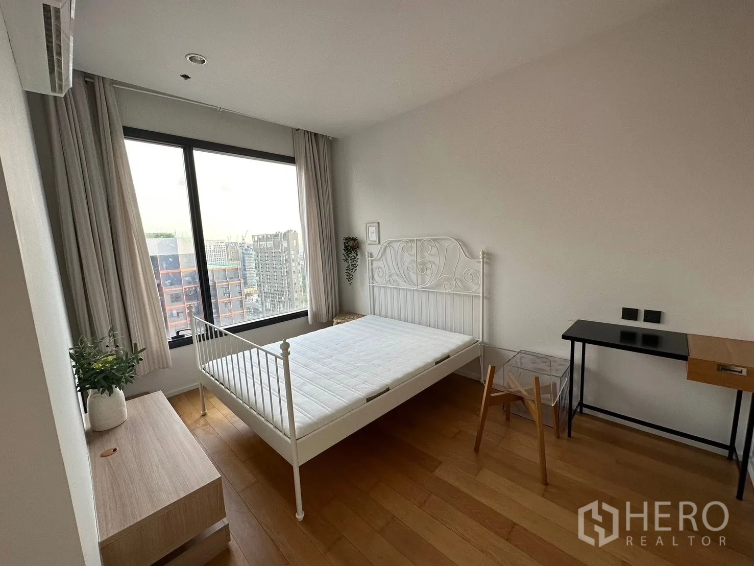 คอนโด for rent or sale in Chatuchak, Bangkok - ห้องนอนมีหน้าต่างบานใหญ่ มองเห็นวิวเมือง พร้อมเตียงและโต๊ะทำงาน