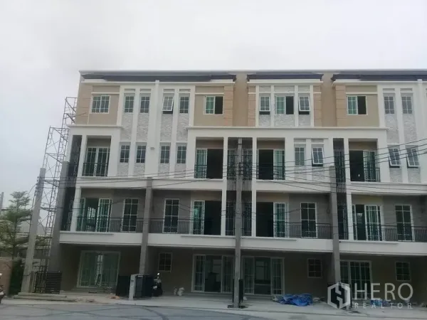 带办公室的家 出租在Bang Na, Bangkok - 四层现代住宅办公楼外立面，设阳台与高窗，位于Bang Na封闭式社区内。