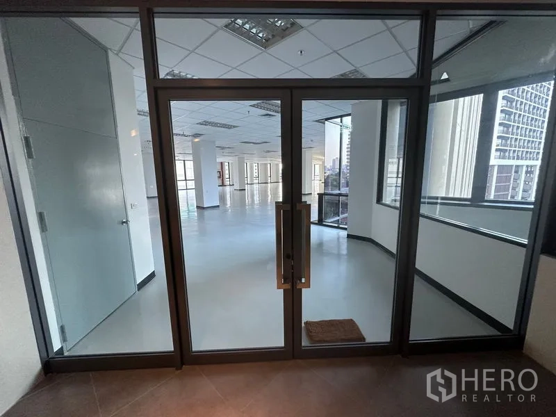 สำนักงาน ให้เช่า - ประตูกระจกบานคู่ทางเข้า สู่พื้นที่สำนักงานเปิดโล่งสว่างพร้อมหน้าต่างมุมมองเมือง