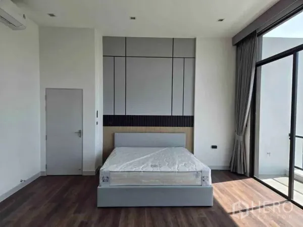 บ้าน ให้เช่าในBang Phli, Samut Prakan - ห้องนอนกว้าง ผนังตกแต่ง เตียงคู่ และประตูกระจกเต็มบานเปิดสู่ระเบียง