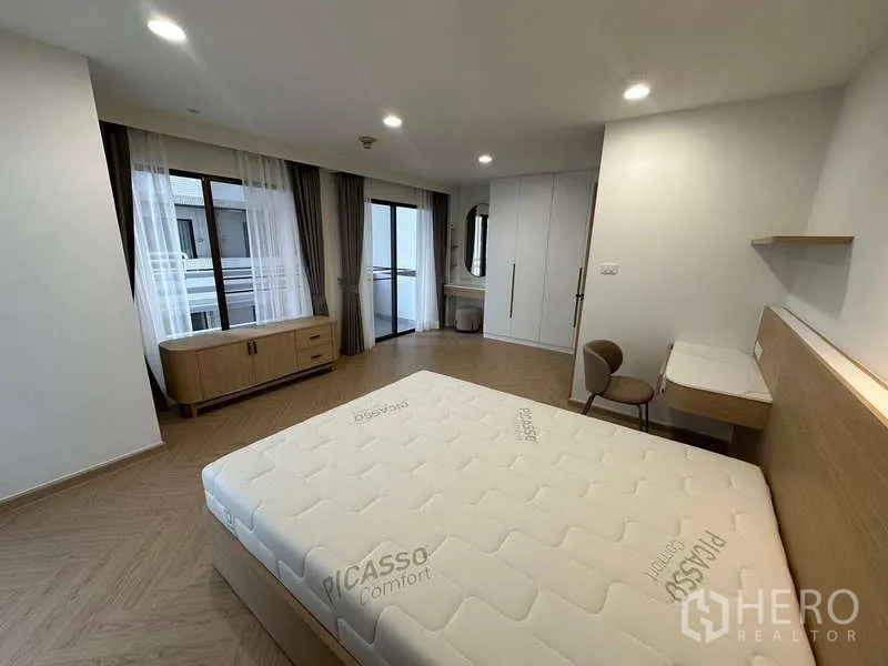 คอนโด ให้เช่าในWatthana, Bangkok - ห้องนอนสว่างพร้อมโต๊ะทำงาน หน้าต่าง และประตูกระจกสู่ระเบียง