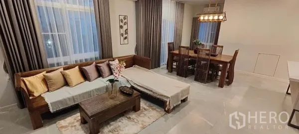 บ้าน ให้เช่าในPrawet, Bangkok - พื้นที่นั่งเล่นและรับประทานอาหารแบบโอเพ่นแพลน พร้อมโซฟาไม้และโต๊ะอาหารหกที่นั่ง.